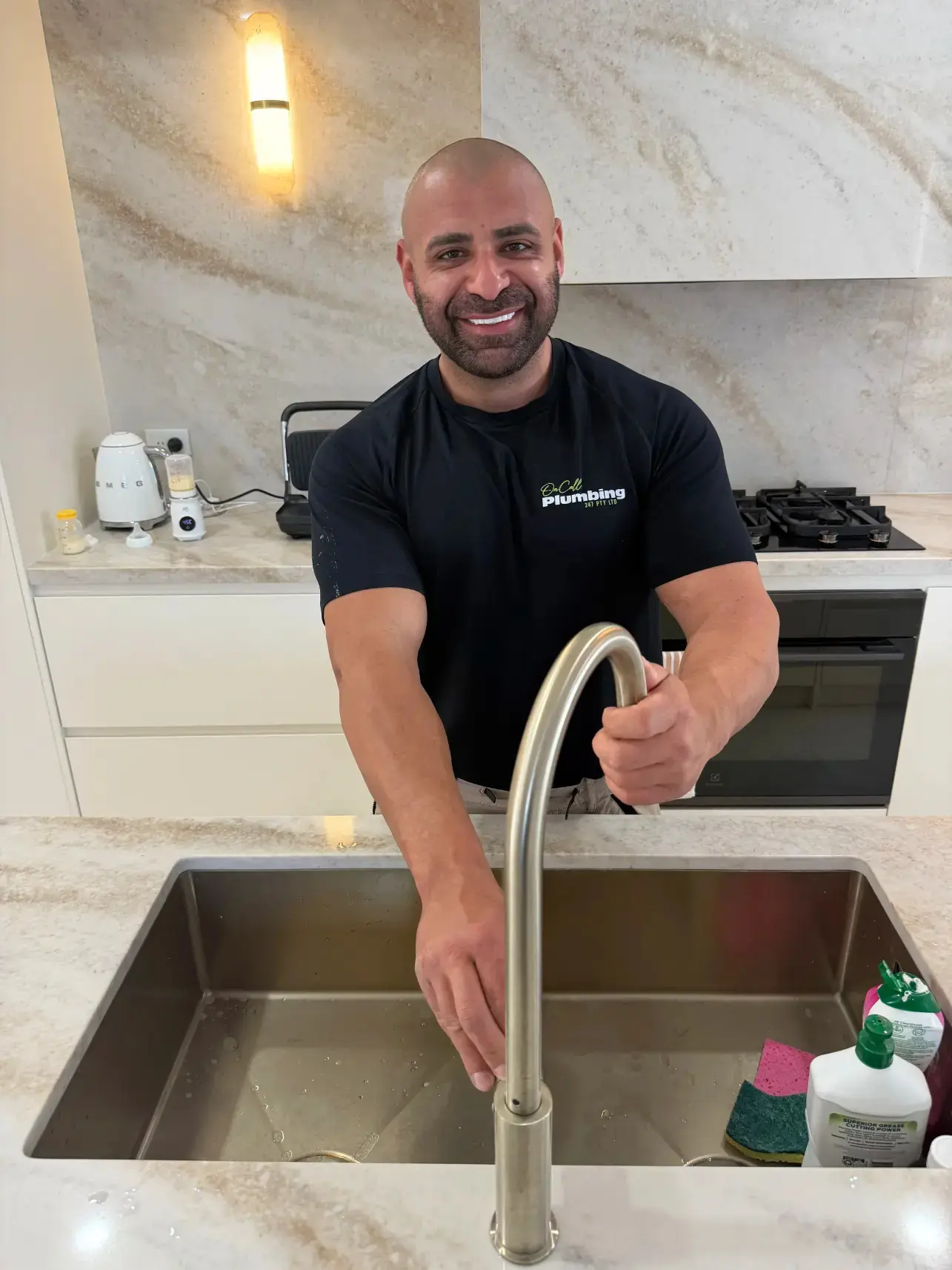 Sam, the On Call Plumbing owner, fitting a kitchen mixer tap in a Canberra home