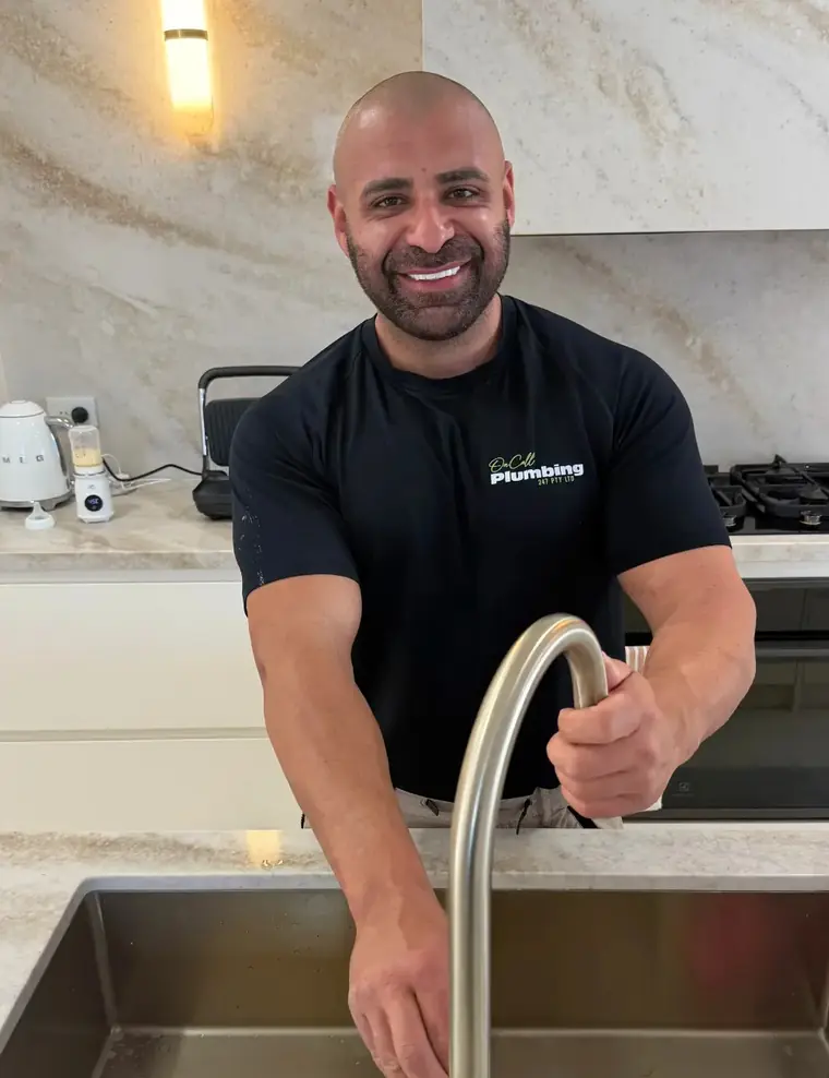 Sam, the On Call Plumbing owner, at a kitchen tap in a Canberra home