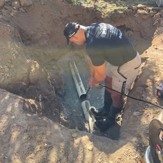 Sam from On Call Plumbing laying drain pipe on a Canberra job