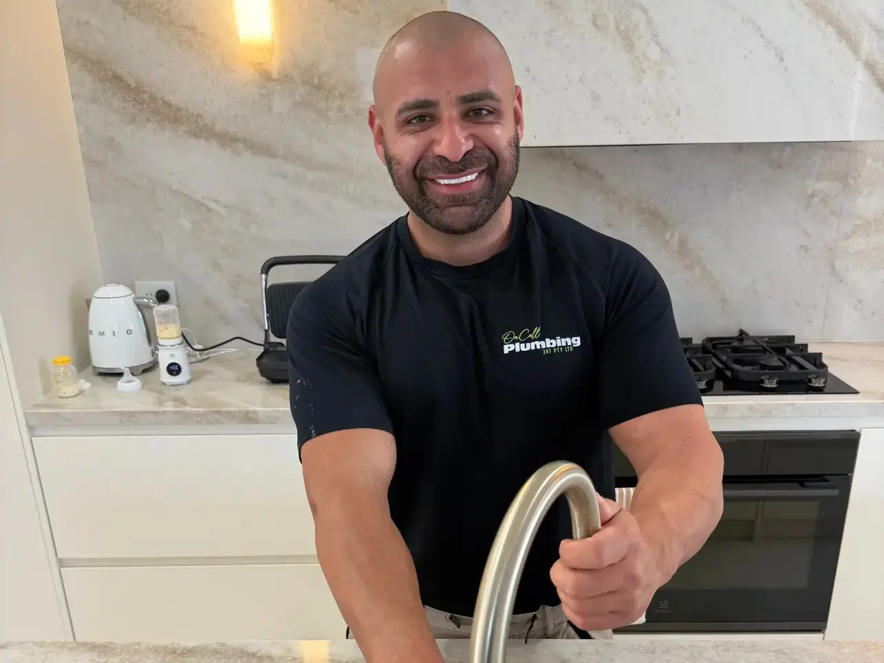 Sam from On Call Plumbing checking a kitchen mixer tap in Canberra