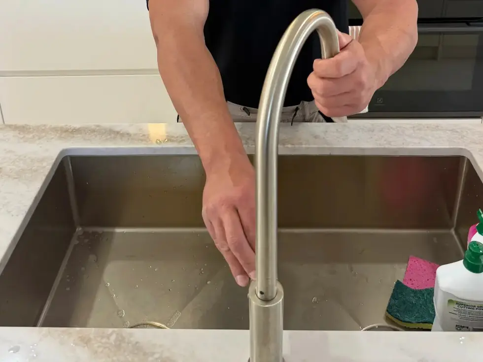 On Call Plumbing fitting a kitchen mixer tap over the sink in Canberra